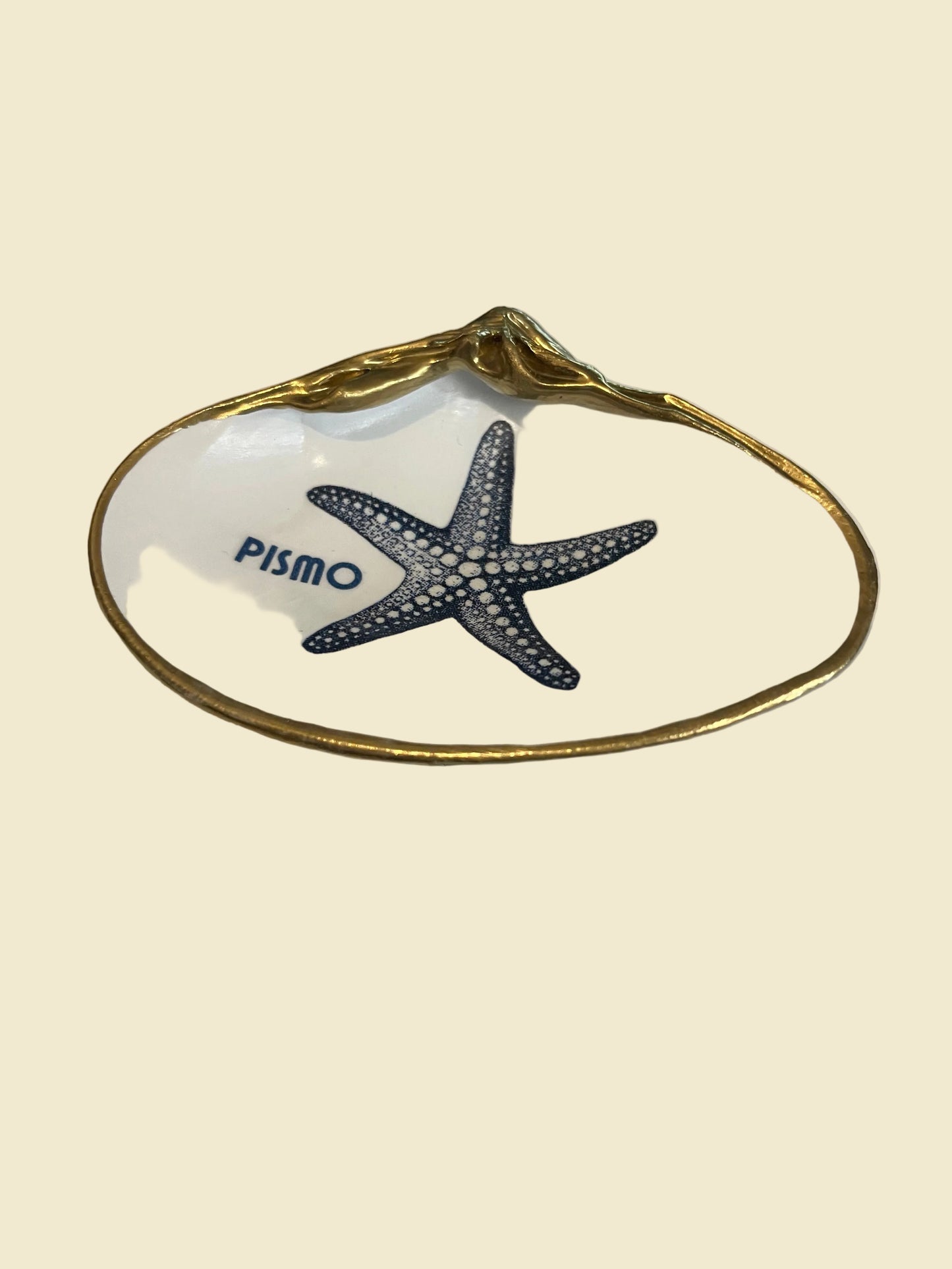 Decorative shell with a starfish design and 'Pismo Beach' text on a white background