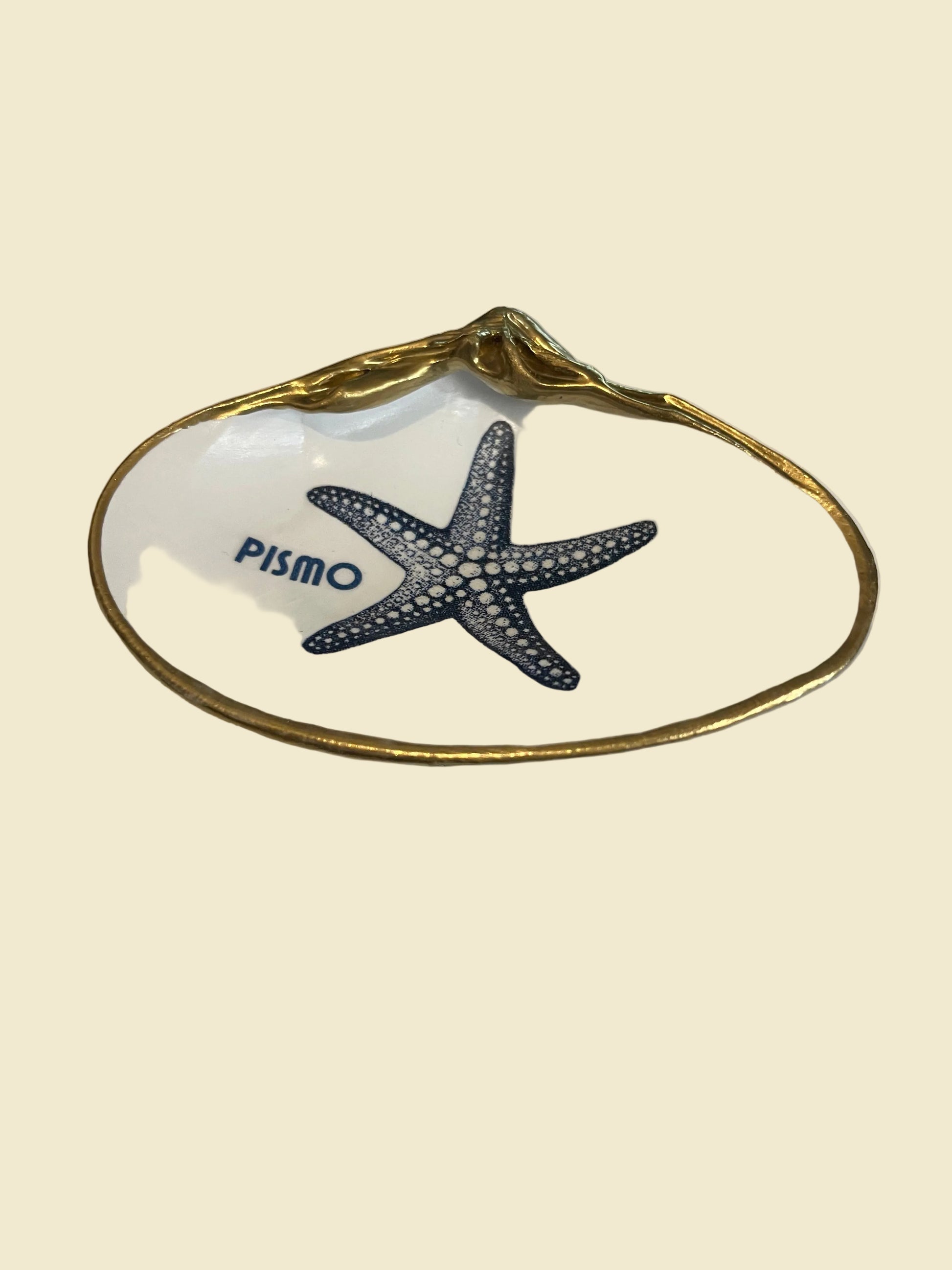 Decorative shell with a starfish design and 'Pismo Beach' text on a white background